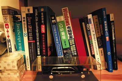 ▼汪正扬的书桌旁放着很多计算机编程的书籍。汪正扬电脑编程等技术全部自学。 